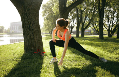 Девушка делает зарядку на природе.